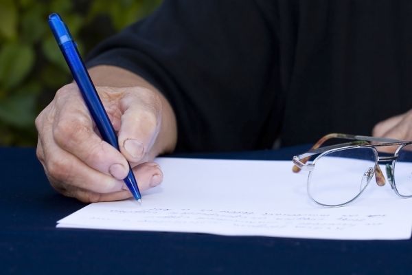 Woman's hand holding a pen writing