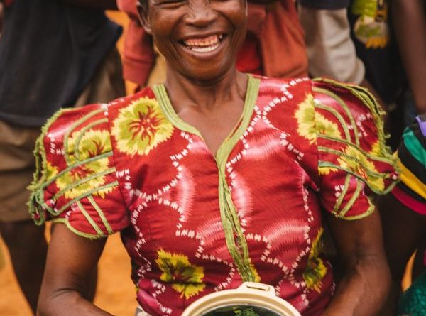 Joyous Woman Holding a Food Plate in Malawi